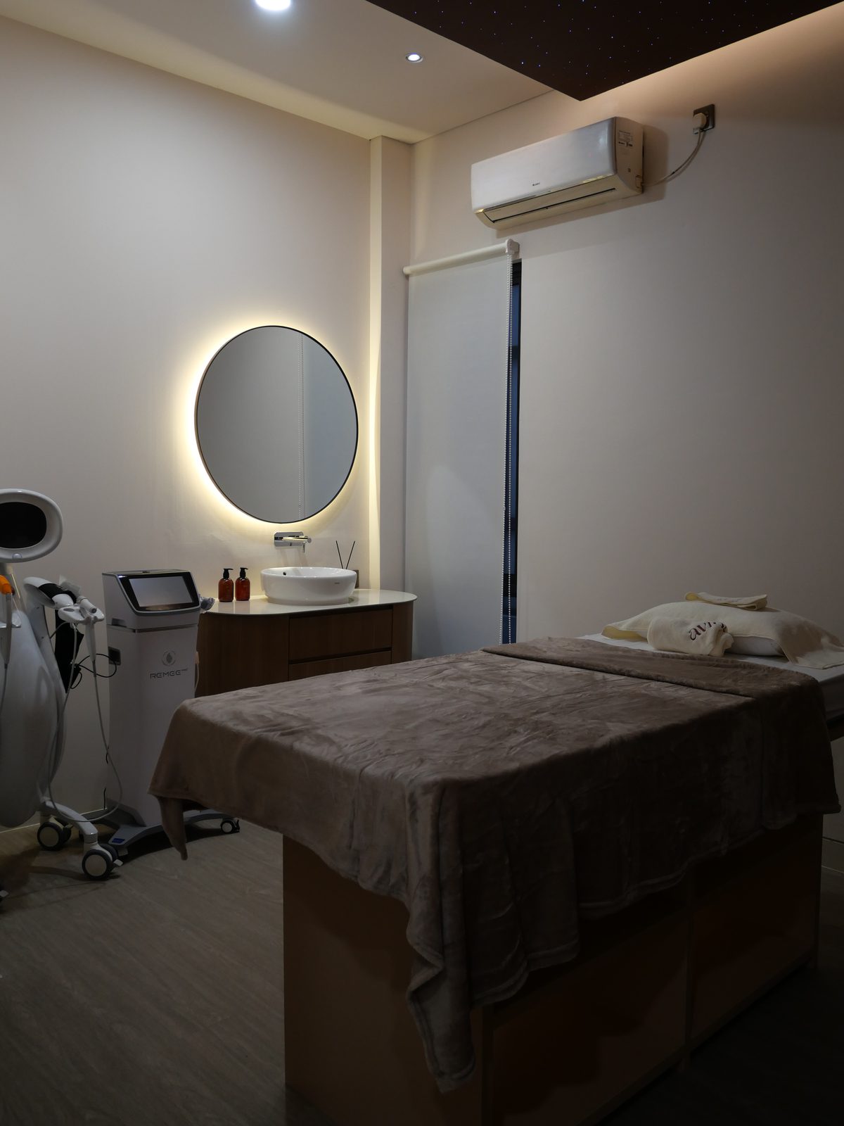 Treatment bed beside a circular backlit mirror