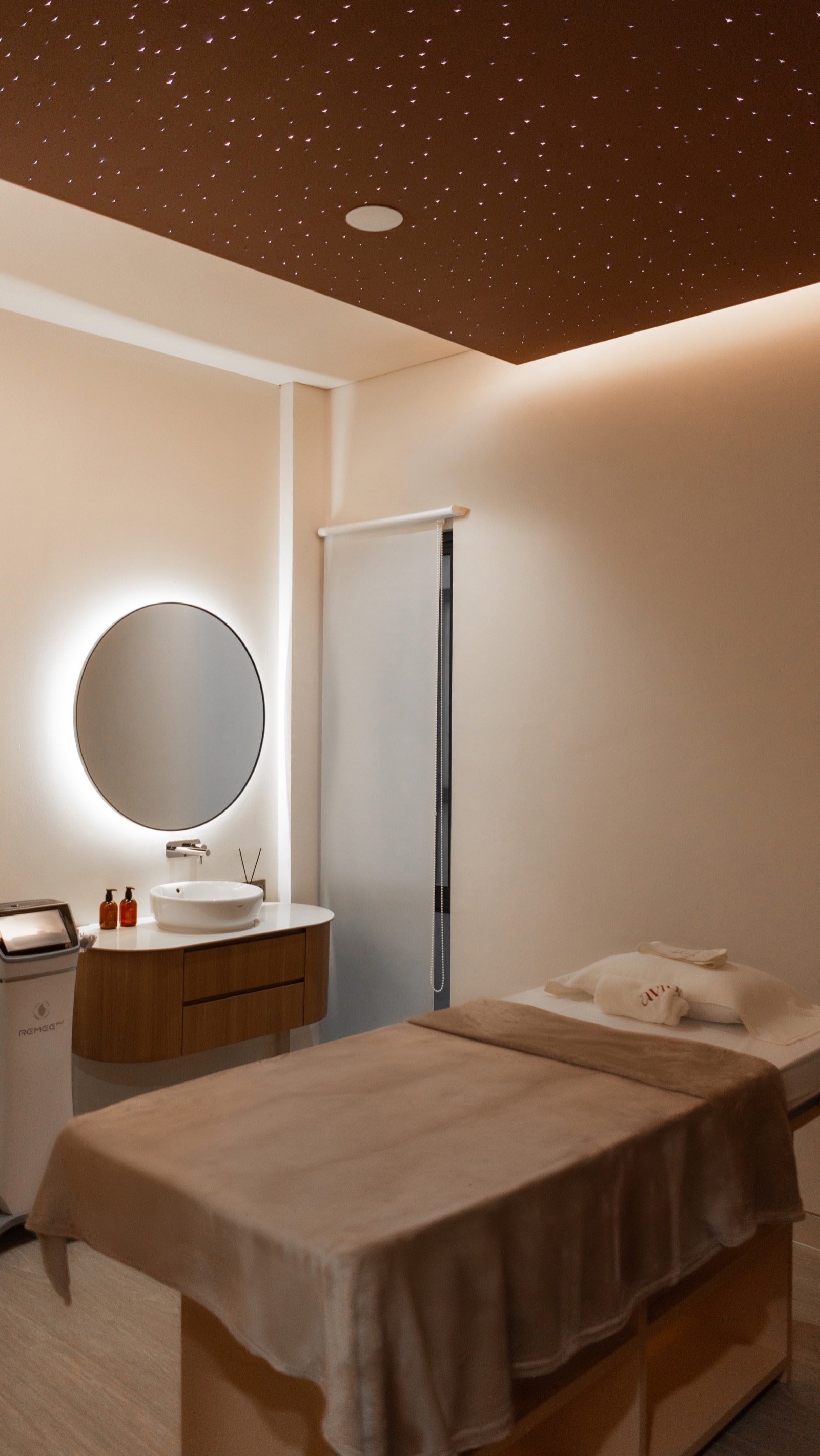 Aviora VIP treatment room — circular backlit mirror, warm wood, considered detail